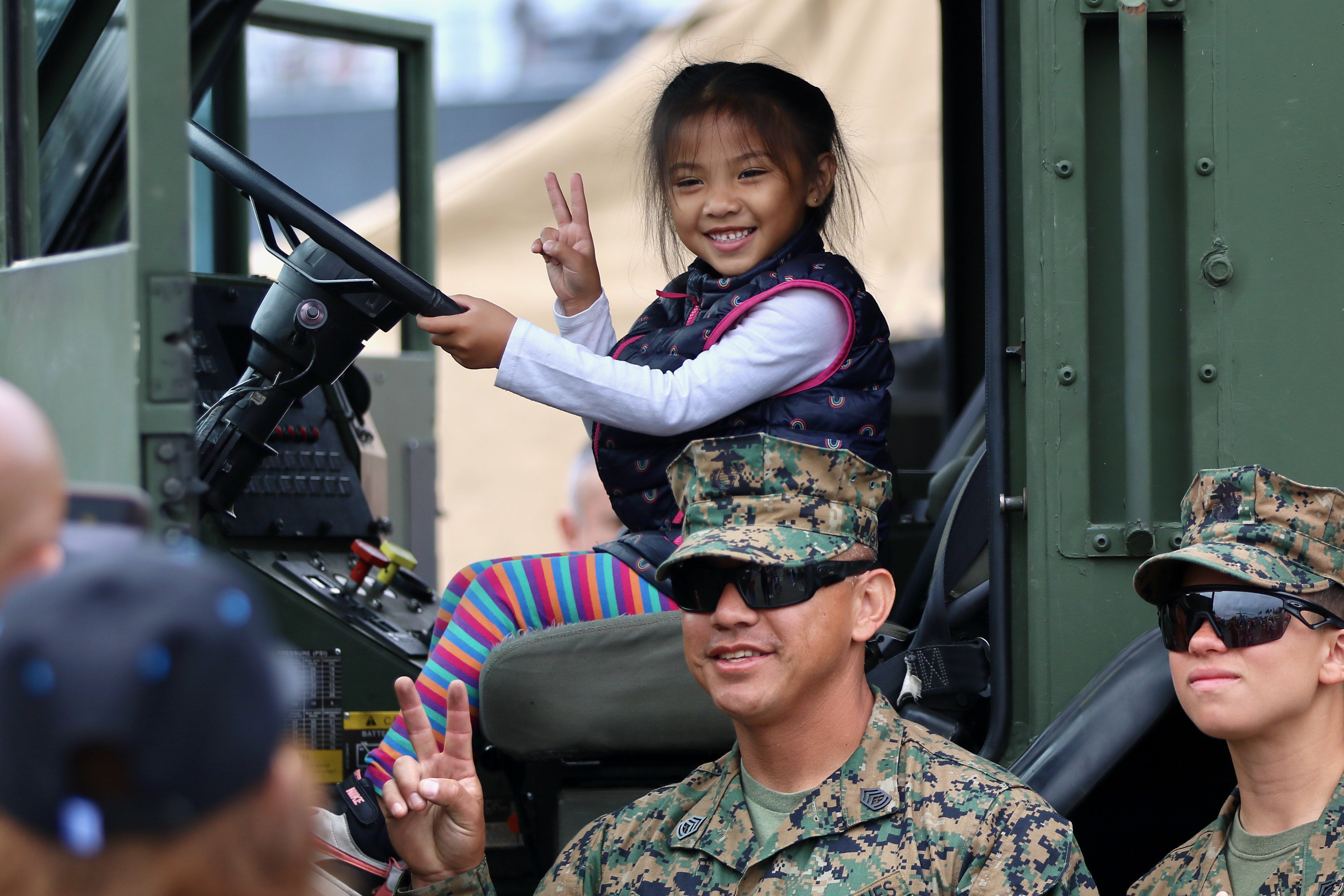 Visitors learn about equipment as they interact with military personnel...