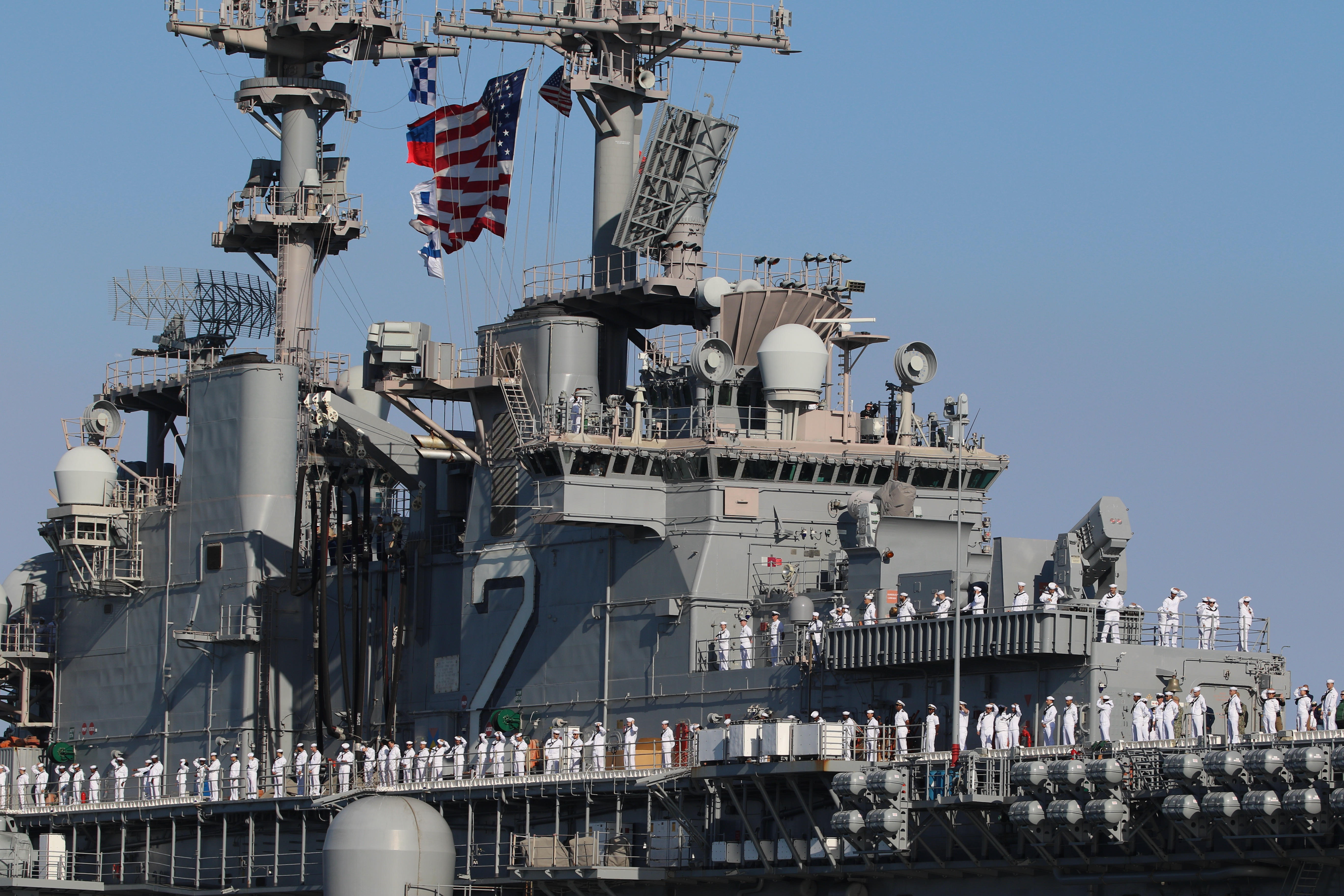 Sailors man the rails as the USS Essex arrives in...