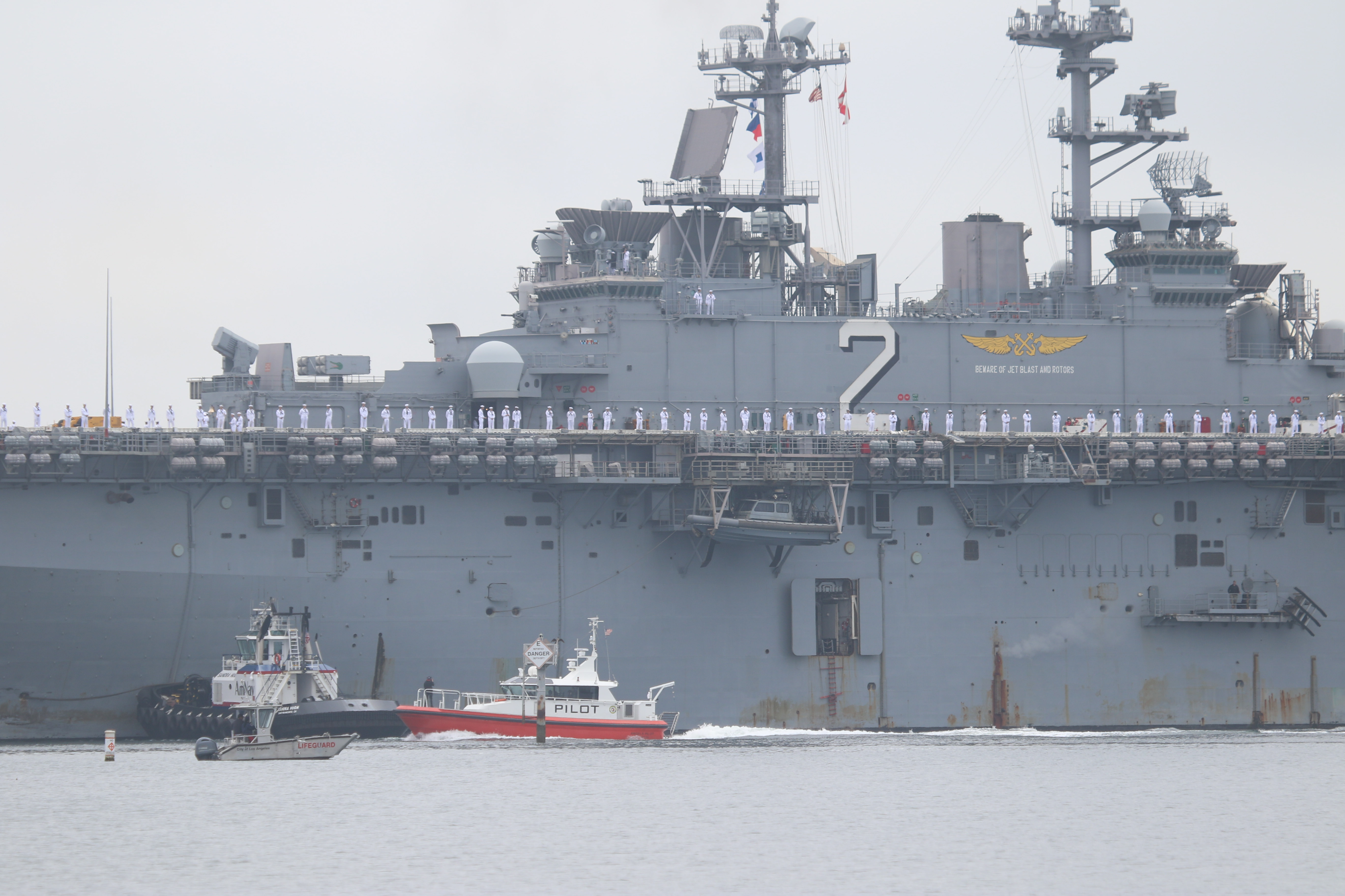 Sailors man the rails as the USS Essex arrives in...