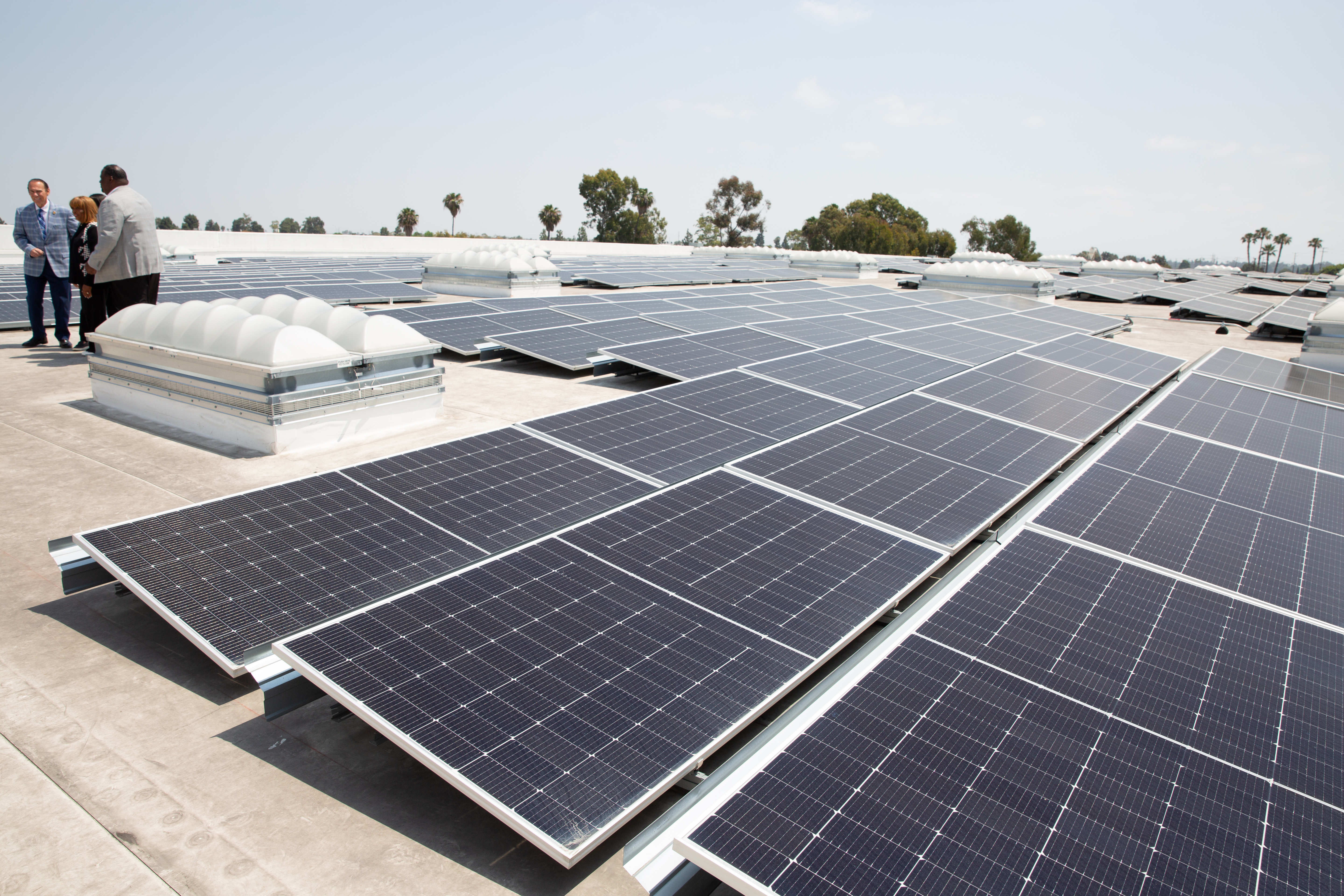 Rows of solar panels sit on a rooftop during an...