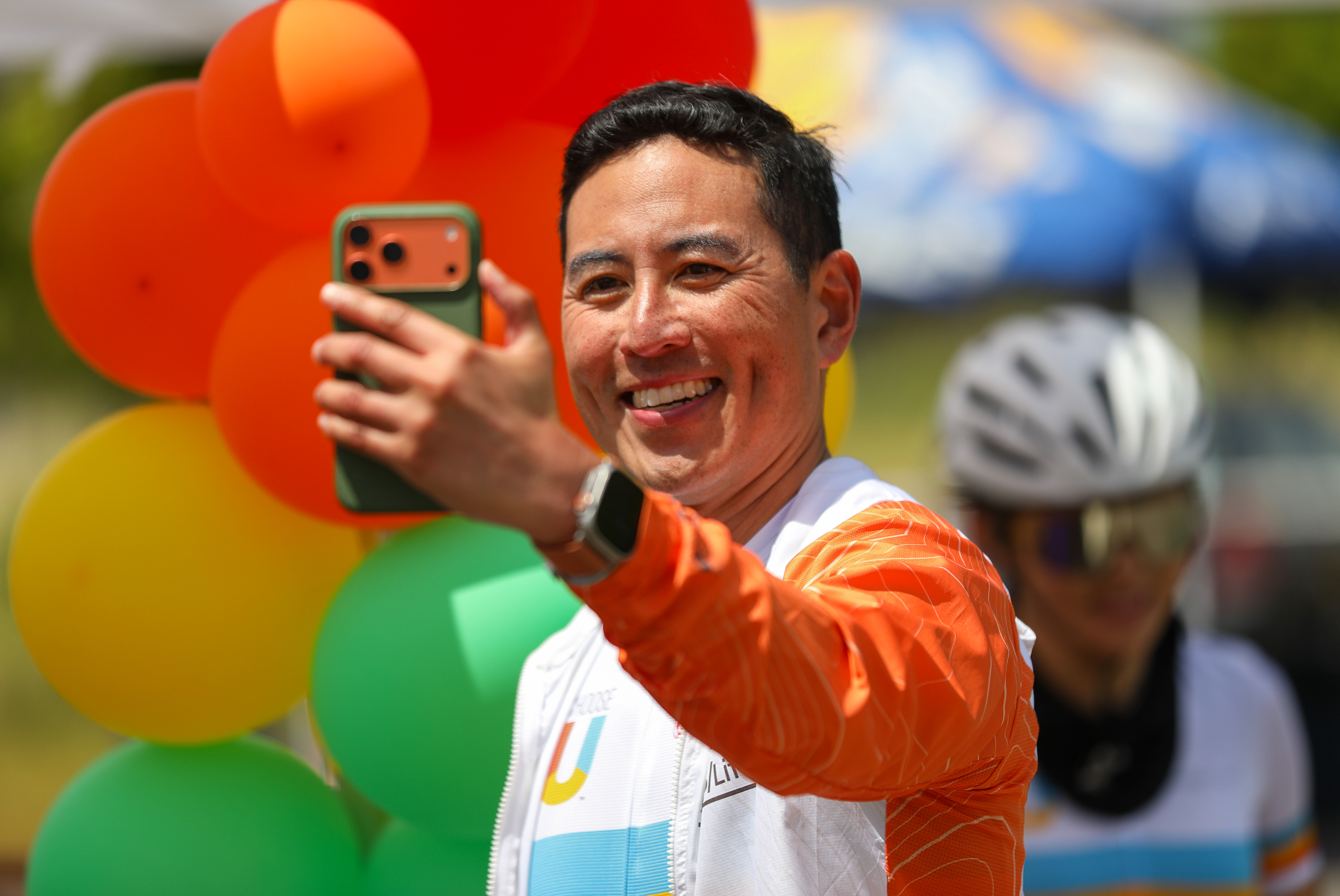 Stephen Chien takes a selfie in front of colorful balloons...