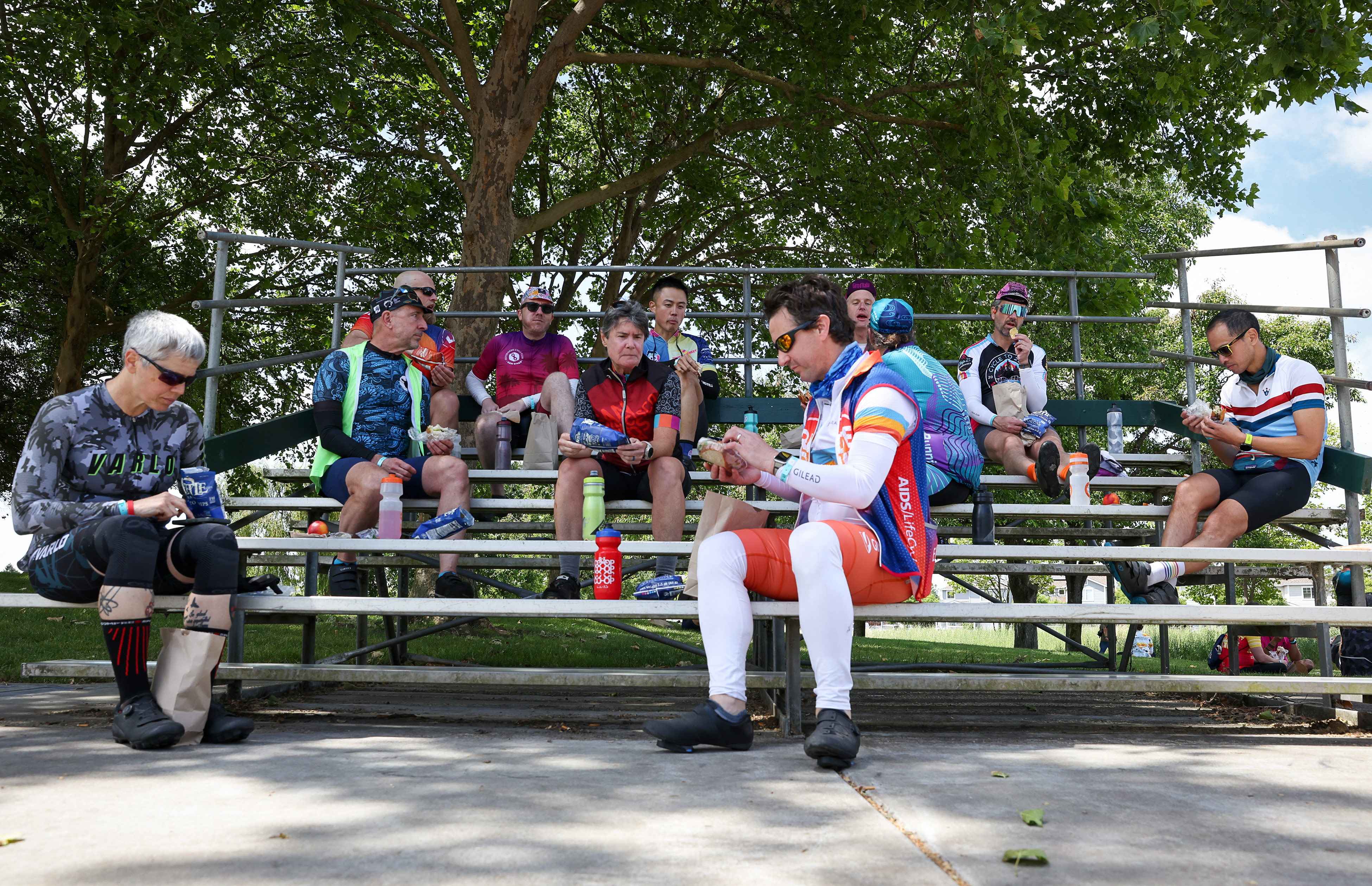 Cycle to Zero bicyclists eat lunch on the bleachers at...