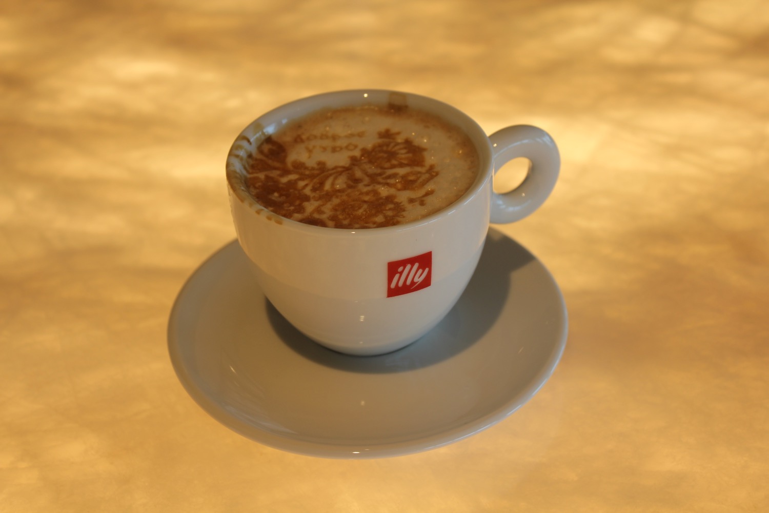 a cup of coffee with a design on top of it