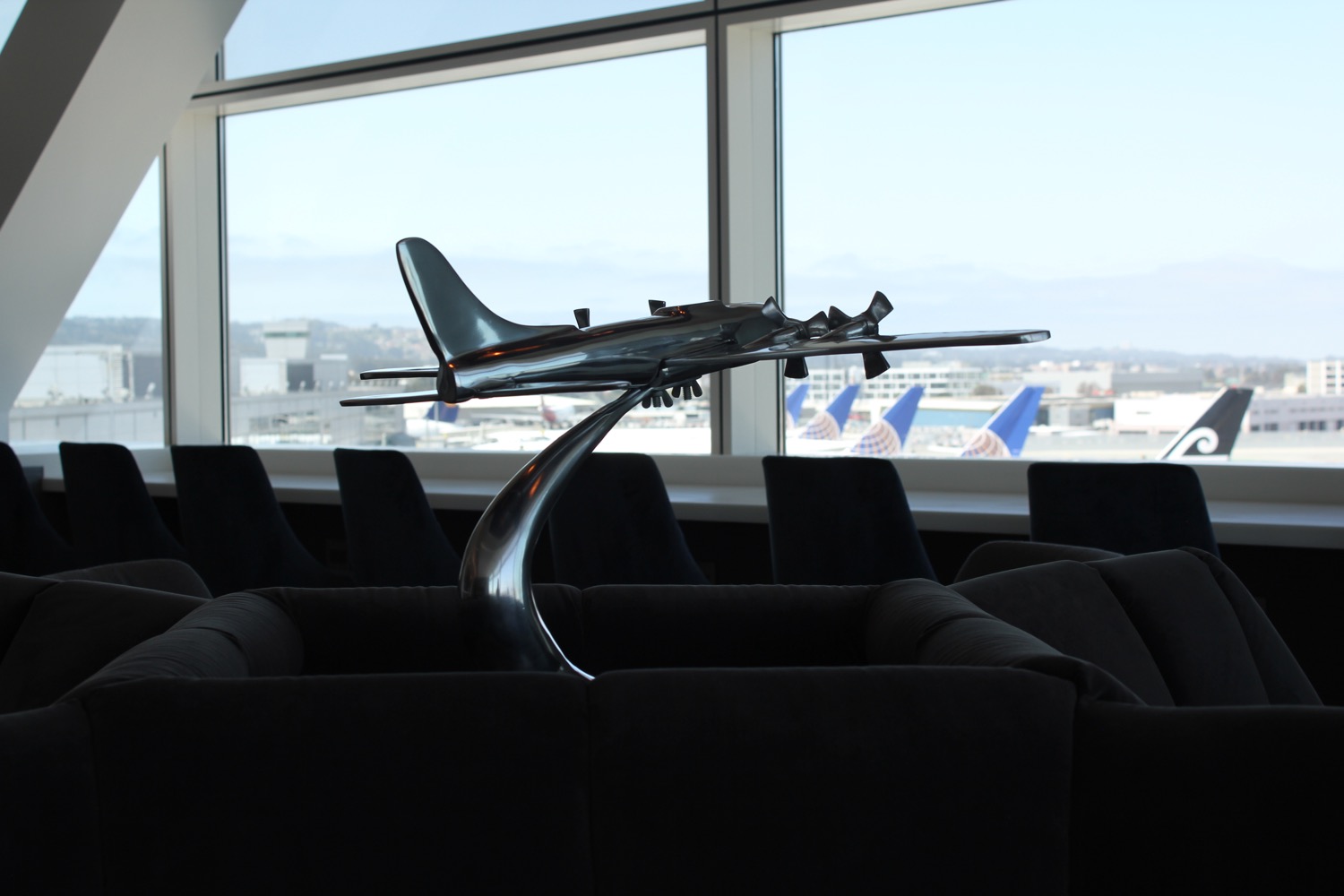 a model airplane on a stand in a room with windows