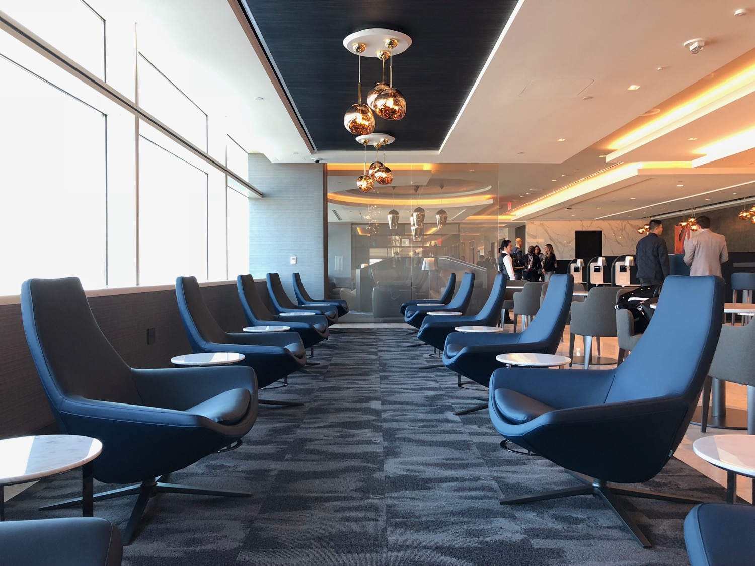 a room with blue chairs and a large window