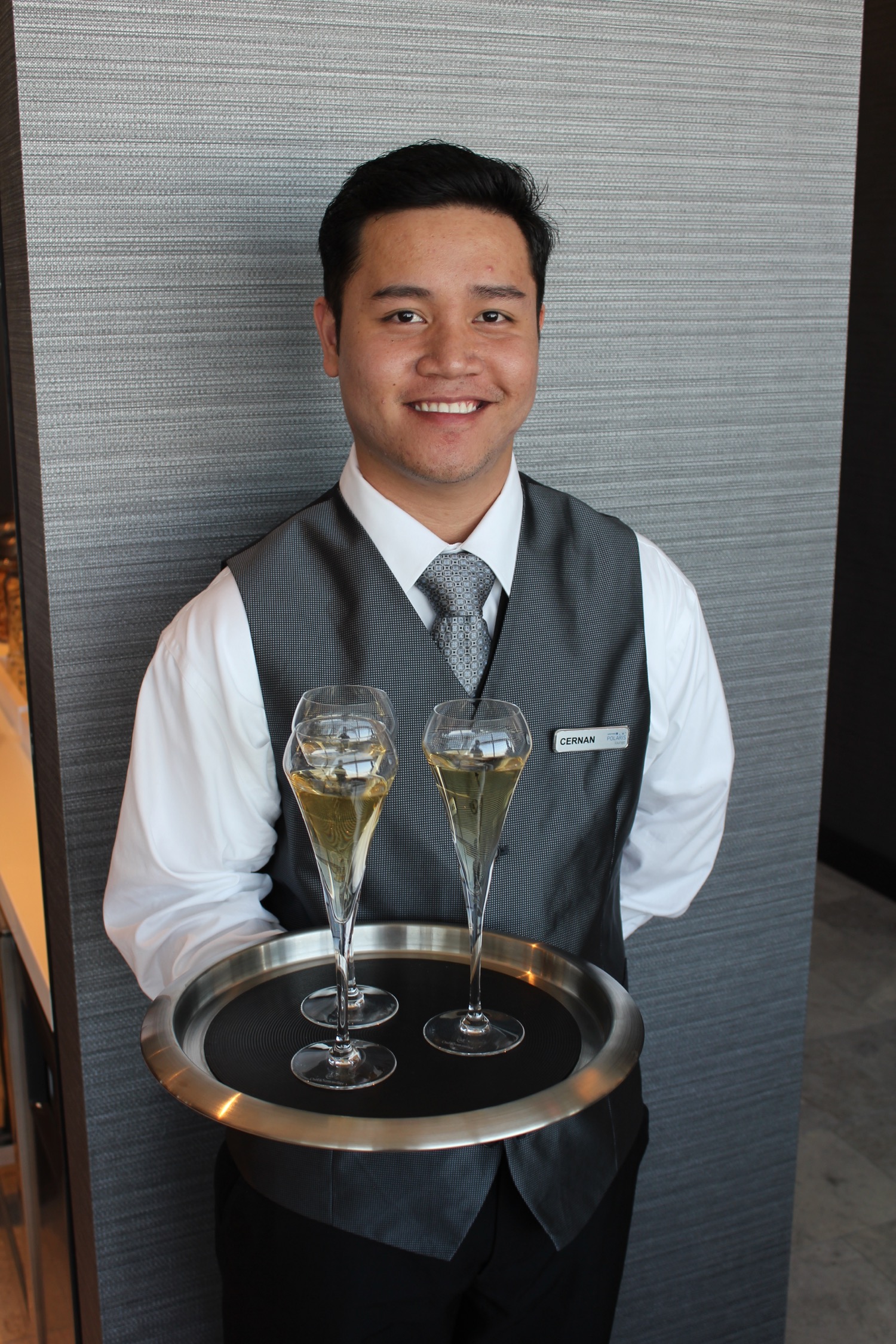 a man holding a tray of wine glasses