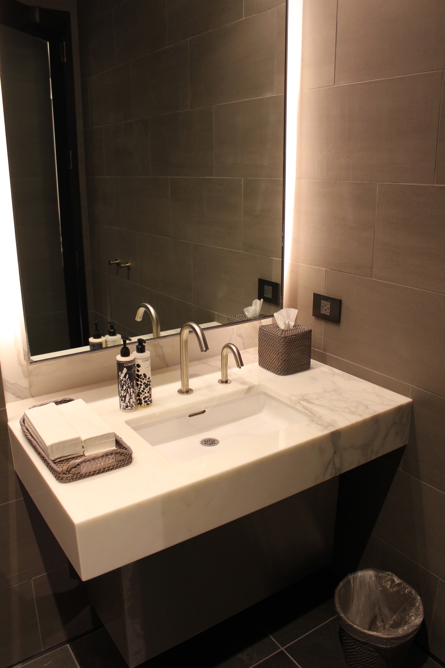 a bathroom sink with a mirror and a tray of soaps