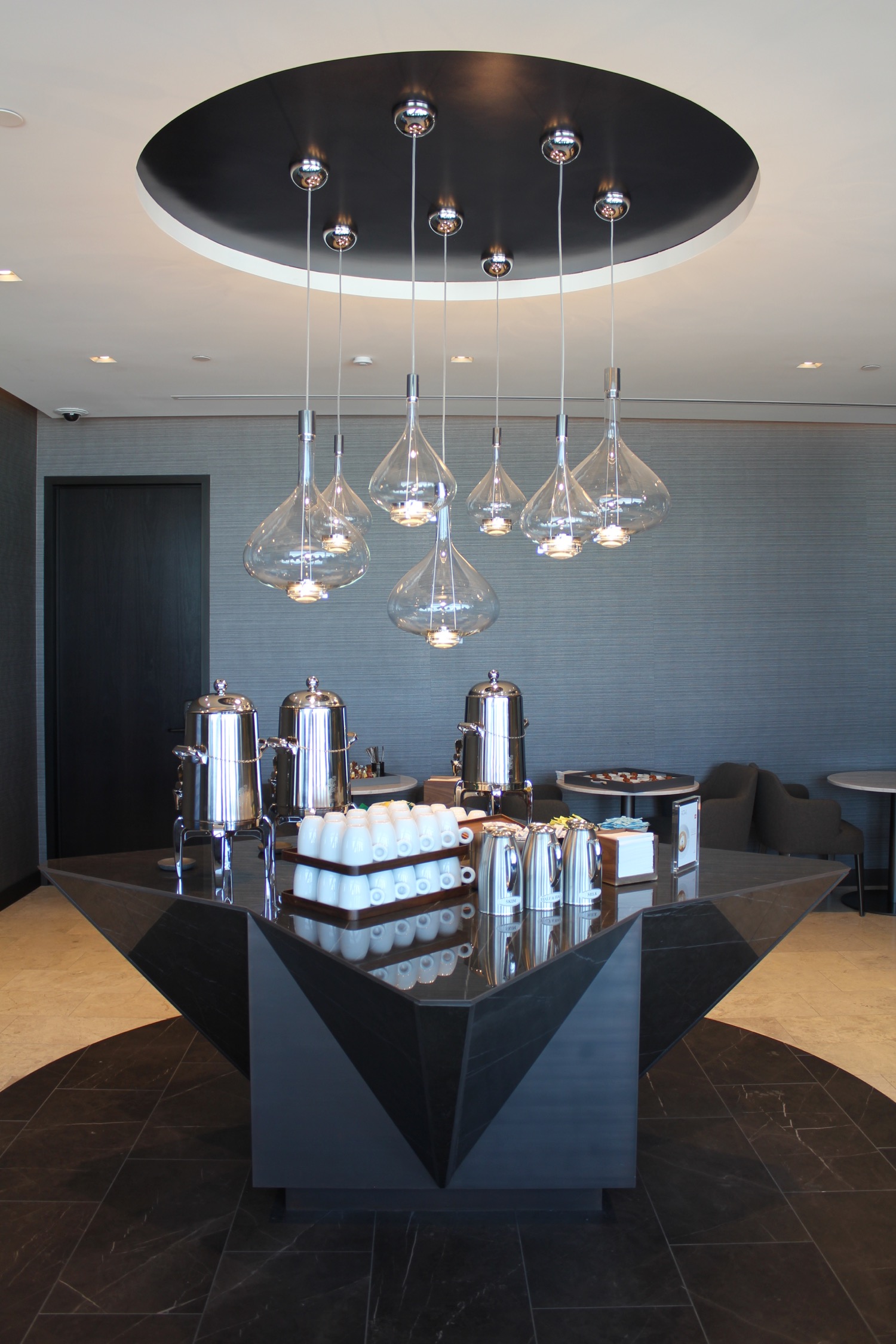 a black triangular table with a group of clear lights from the ceiling