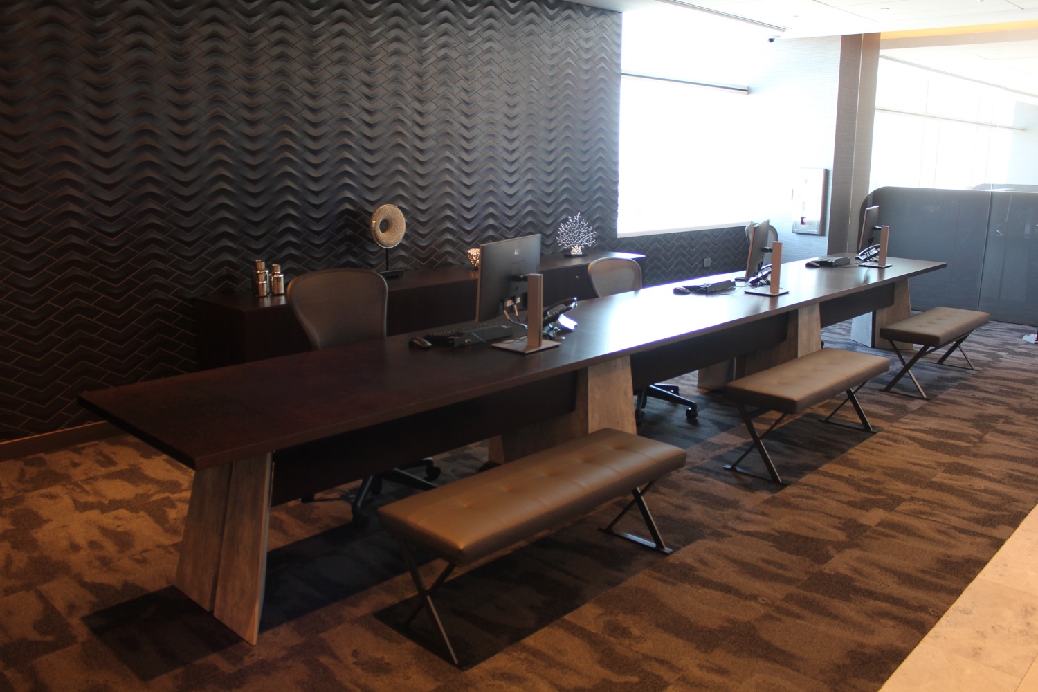 a desk with computers and benches in a room