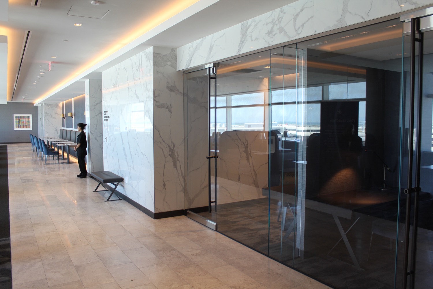 a man standing in a hallway with a glass wall