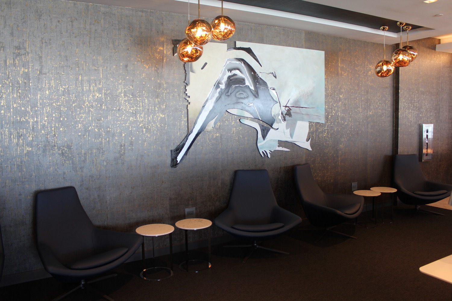 a group of chairs and a painting on the wall
