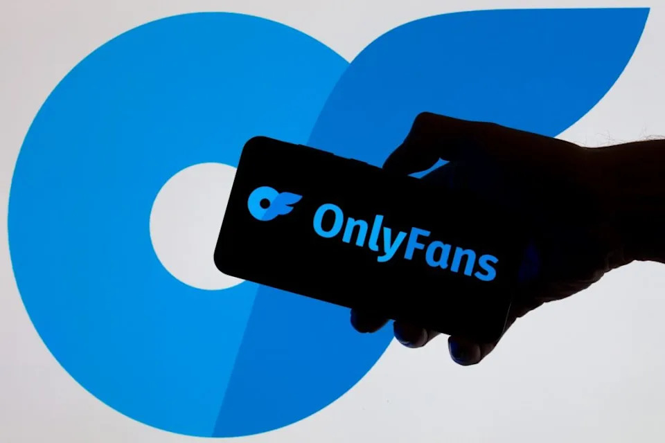 The OnlyFans logo is displayed on a mobile phone with the company branding icon visible in the background in this photo illustration. (Photo by Jonathan Raa/NurPhoto via Getty Images)