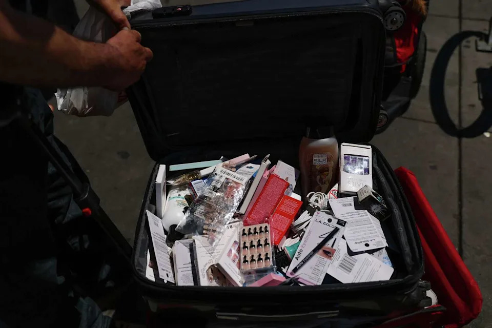 Nicholas Cosmos, left, shows off the various items he sells, including press on nails, at 24th and Mission Streets in San Francisco, Calif., on Thursday, May 21, 2026. The police make their presence known in the area in an attempt to curb illegal vending. (Gabrielle Lurie/S.F. Chronicle)