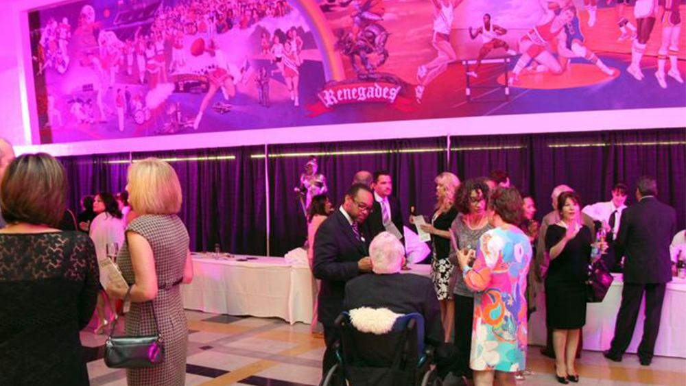 large room hosting a reception with guests and finger foods
