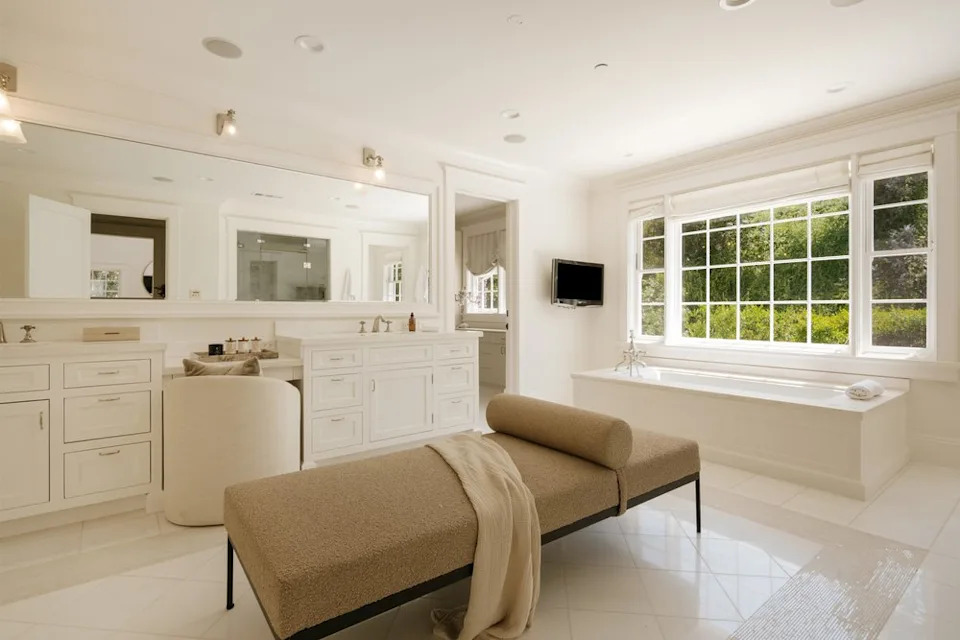 The primary suite also boasts a stunning—and very large—ensuite bathroom with a huge soaking tub, double sinks, a vanity space, and a huge walk-in shower. <span class="image-credit">(Christian Cruzio Studios)</span>