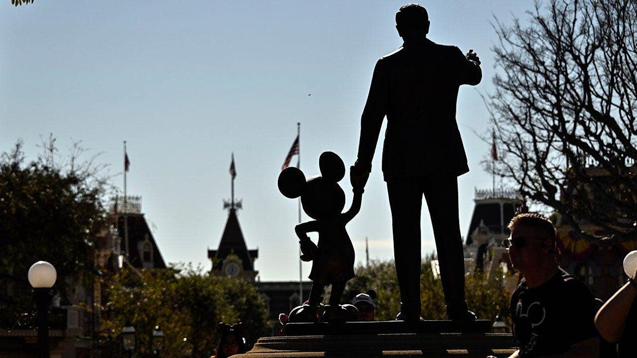 Statue of Walt Disney holding Mickey Mouse's hand outside Sleeping Beauty Castle at Disneyland