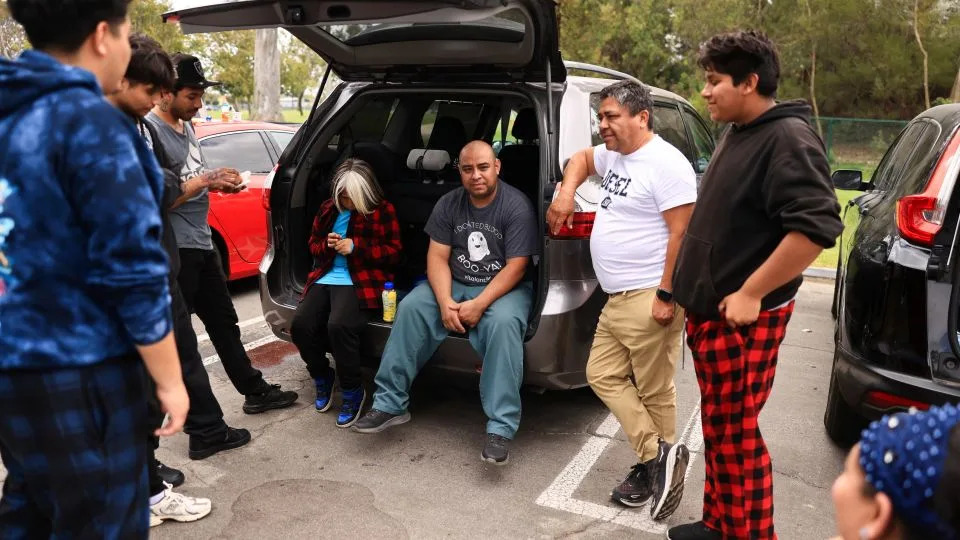 People gather outside a shelter for evacuees in Fountain Valley, California, Saturday. - David Swanson/Reuters
