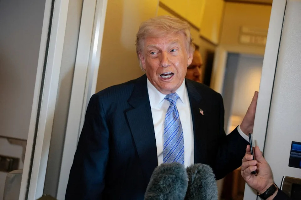 President Donald Trump speaks to media on Air Force One. REUTERS