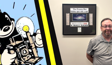 man stands next to a fresno bee framed page