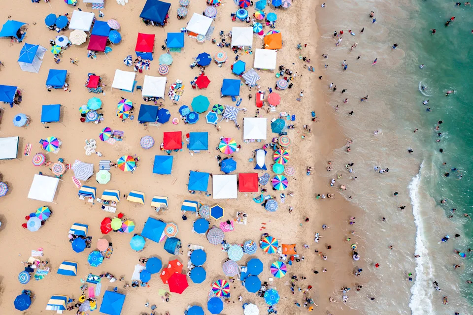 Aerial view top down of a crowded beach with wany people and umbrellas on a holiday weekend