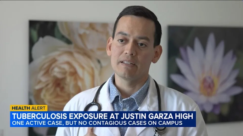 A male health official in a white lab coat and stethoscope around his neck, speaking about a tuberculosis exposure at Justin Garza High School. ABC 30