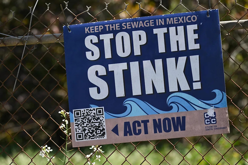 A sign reads "Stop The Stink" near the Tijuana River Valley area by Border Field State Park along the US-Mexico border between San Diego and Tijuana in San Diego County, California, on April 23, 2025. In recent years, the US-Mexico border sewage pollution problem has closed beaches and raised concerns over public health issues.