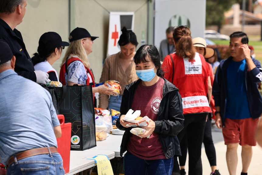 People line up to get food at a red cross evacuation centre