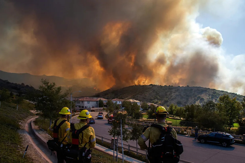 Fire fighters monitor the Sandy Fire as it burns in the hills close to a residential area in Simi Valley, Calif., on May 18, 2026. About 24,000 people in Simi Valley, 40 miles northwest of Los Angeles, are under mandatory evacuation orders as the Sandy Fire is "spreading dangerously fast" according to fire officials.