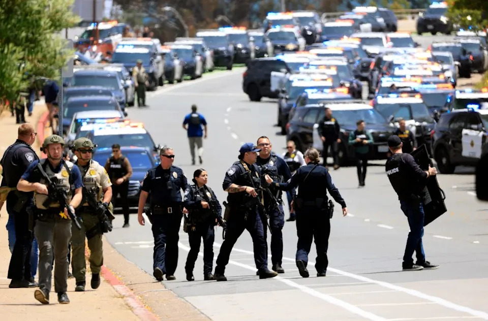 Law enforcement officers escort people away from the Islamic Center of San Diego. The San Diego Union-Tribune via Getty Images