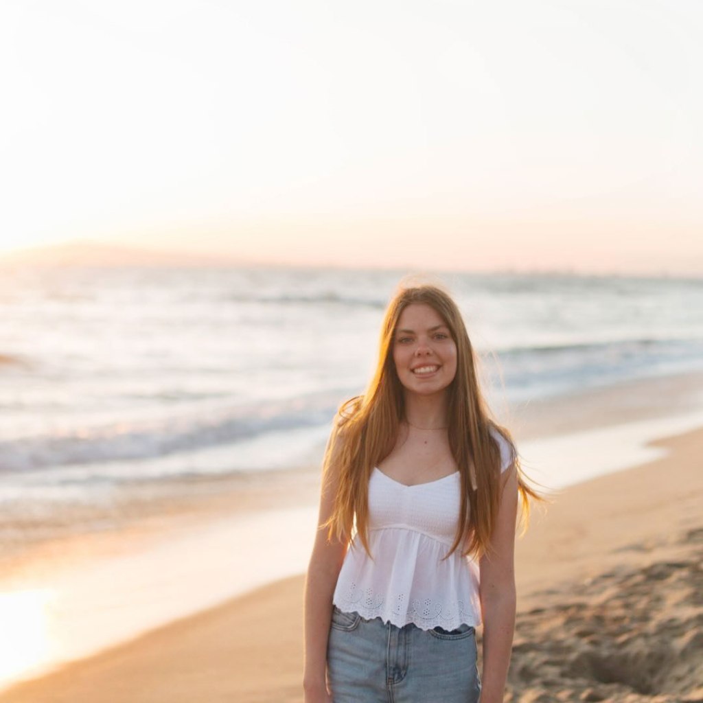 Grace Edwards smiling on a beach.