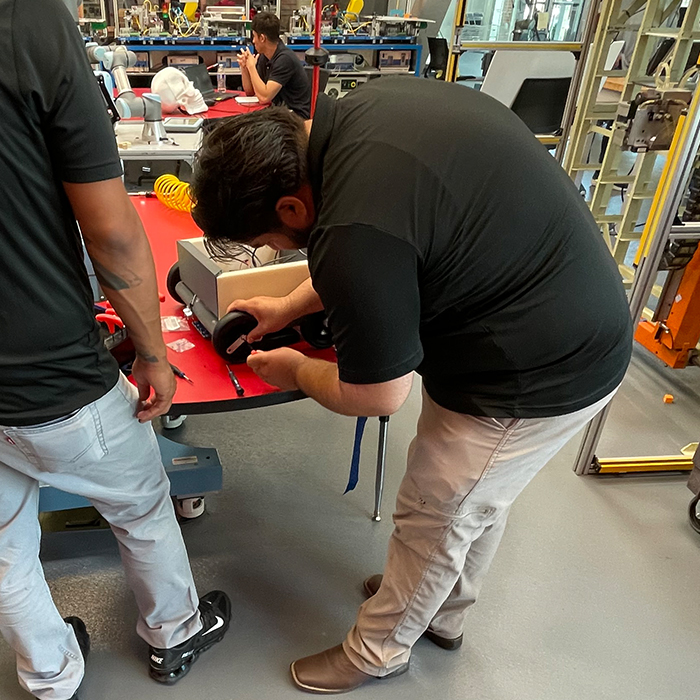 industrial automation student fixing a wheel on a vehicle project