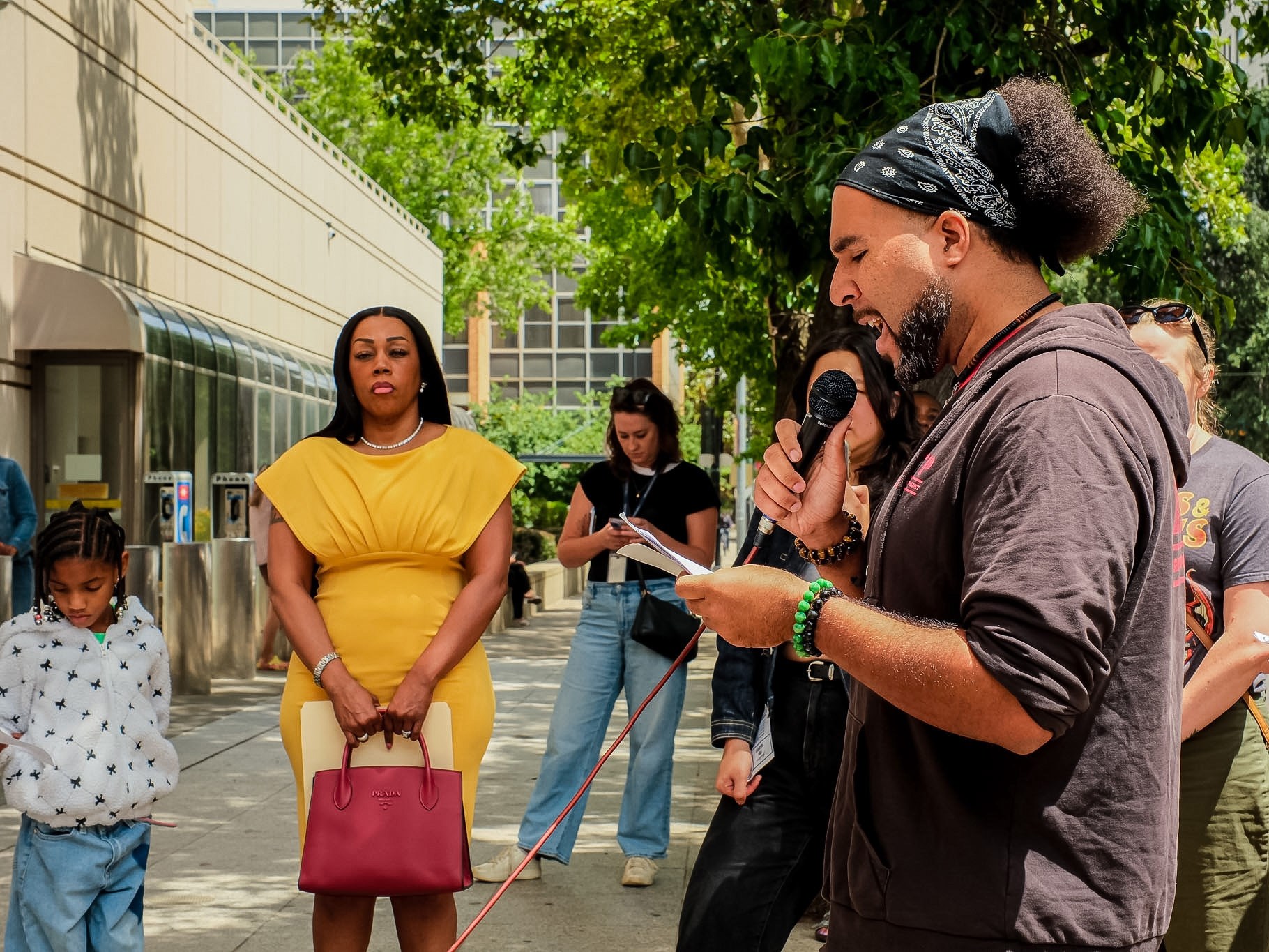 Keyan Bliss (right), an organizer with the Anti-Police Terror Project reads the names of inmates who have died in Sacramento County Jail since 2018, in front of Tonette Washington(left), her family and the rally of advocates on May 28, 2026.