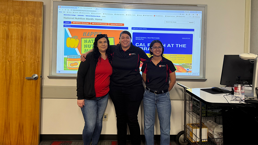 three females standing in a classroom