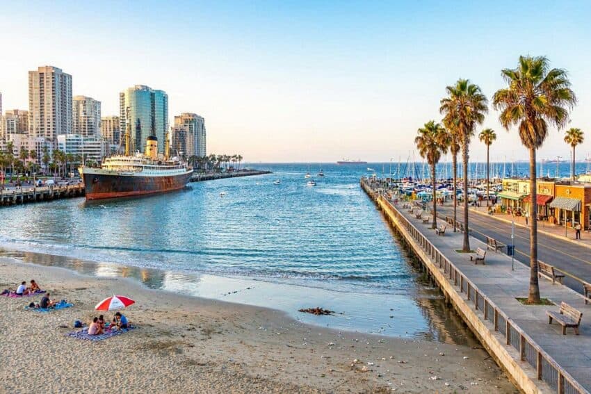 Beach and city skyline in long beach, california, with palm trees and ships.