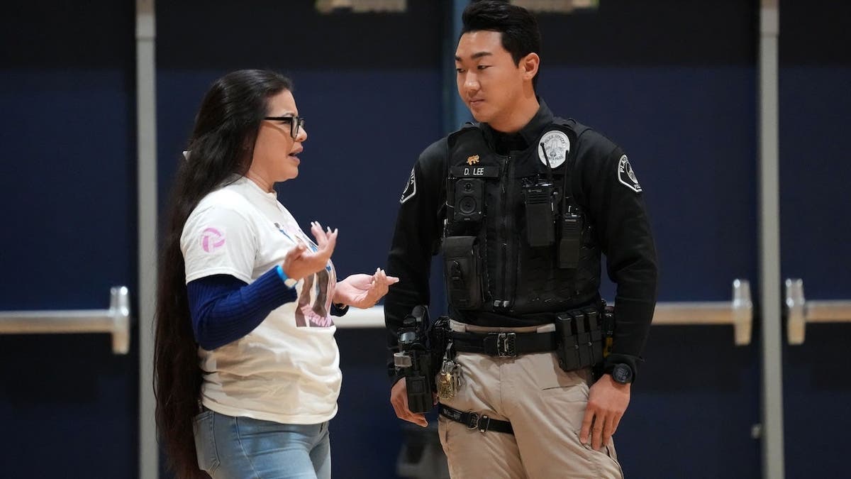 Nereyda Hernandez talking with Placentia police officer Daniel Lee at volleyball playoff match