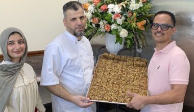 three people holding a tray
