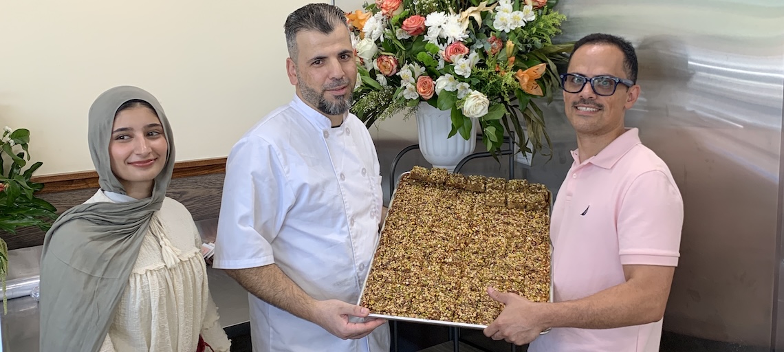 three people holding a tray