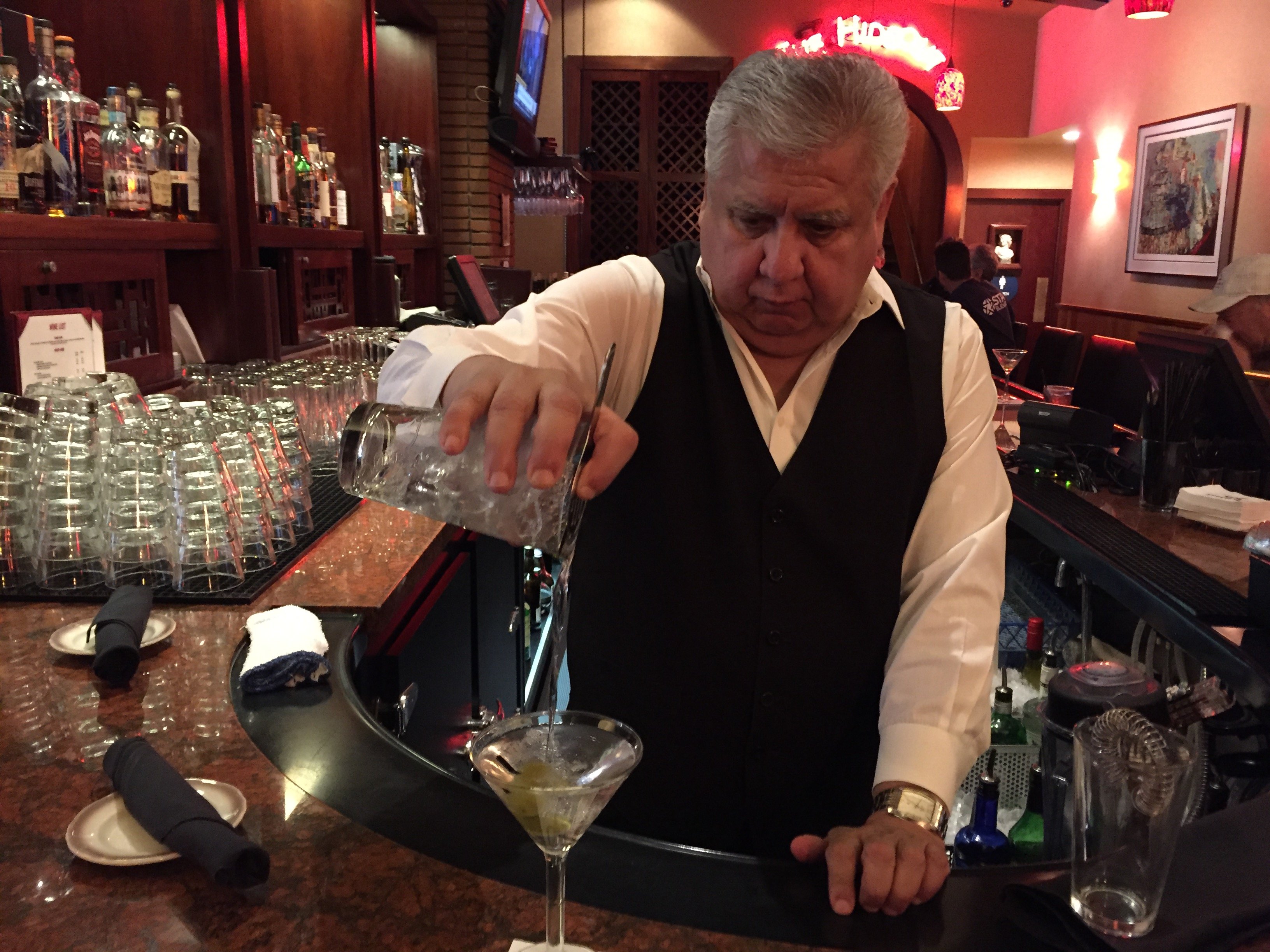Bartender Dave Sanchez pours a martini at Original Joeâs, a...