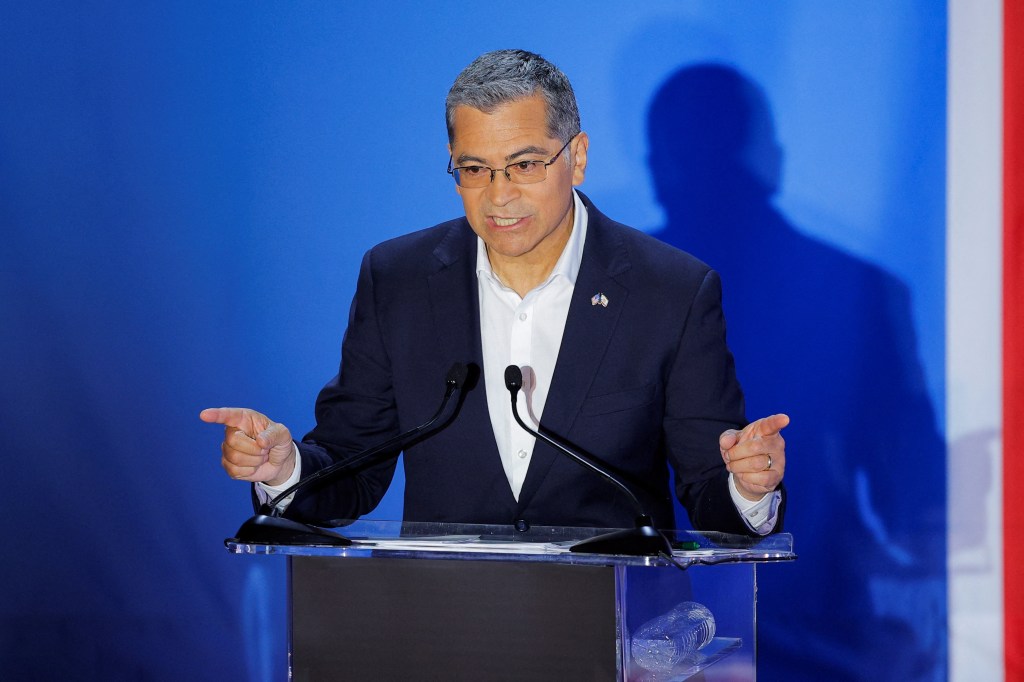 Xavier Becerra speaking at a podium during a gubernatorial debate in Claremont, California.