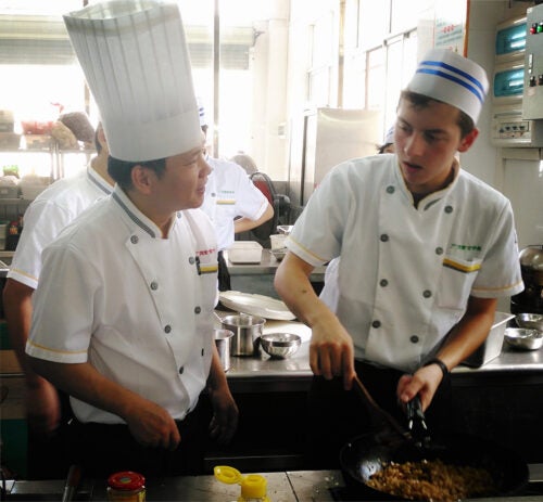 Photo of George Stiffman cooking with fellow chef.