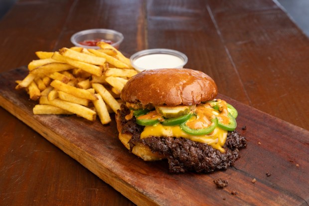 At Farm to Smash in Point Loma on Monday, May 4, 2026, in San Diego, CA, is their classic, Double Flaming Smash burger, with all-natural American cheese, fresh-cut jalapexc3xb1os, and pickles. With a side of fries. They donxe2x80x99t use seed oils and cook their crispy fries twice in beef tallow. (Nelvin C. Cepeda / The San Diego Union-Tribune)