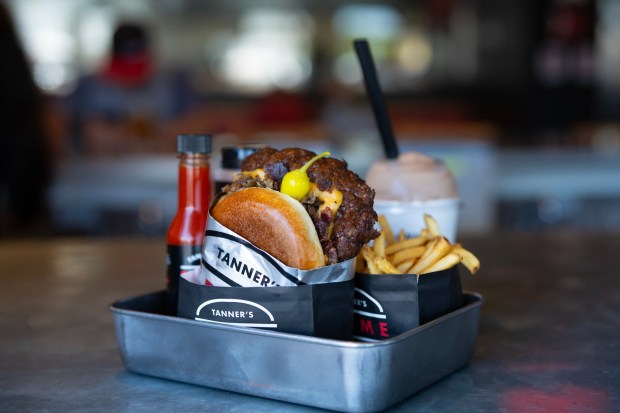 The signature Prime Burger at Tanner's Prime Burgers in Oceanside includes a third-pound patty on a brioche bun topped with cowboy beef bacon, caramelized onions, New School American Cheese, Tanner's sauce, leaf lettuce, tomato and onion slices and a cascabella pepper. (Nelvin C. Cepeda / The San Diego Union-Tribune)
