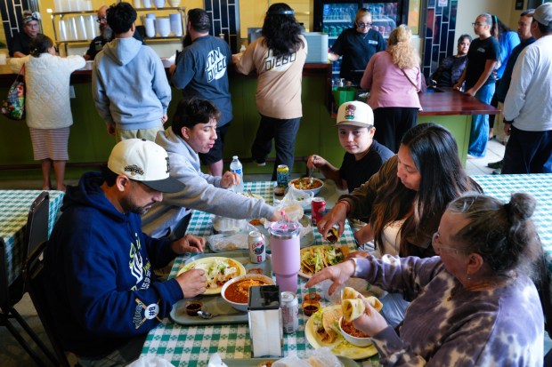 Daniel & Leilani Olivas, along with their two sons, Santiago (l) & Sebastian (r), and his mother-in-law, Margarita Ledesma, enjoy their breakfast at the reopening of Las Cuatros Milpas in Barrio Logan on Tuesday, May 12, 2026, in San Diego, CA. Olivas arrived just after 3am to make sure he was among the first in line to order. (Nelvin C. Cepeda / The San Diego Union-Tribune)