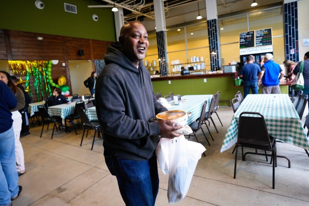 Frank Sharpe of southeastern San Diego arrived at the reopening of Las Cuatros Milpas in Barrio Logan on Tuesday with his own container to have filled with rice, beans and chorizo. (Nelvin C. Cepeda / The San Diego Union-Tribune)