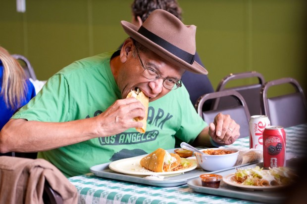 On Tuesday, May 12, 2026, in San Diego, CA, David Ramirez of North Park, a customer of more than 30 years, enjoys a taco during the reopening of Las Cuatros Milpas in Barrio Logan.  (Nelvin C. Cepeda / The San Diego Union-Tribune)