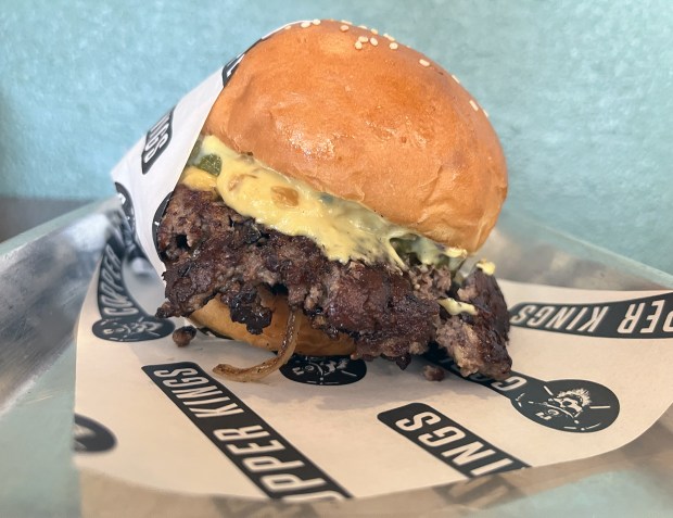 The Burger at Copper King Burgers in North County has two 3-ounce smash-style beef patties on a house-baked bun with house-made American cheese, fried onions, pickles and Copper sauce. (Pam Kragen / The San Diego Union-Tribune)