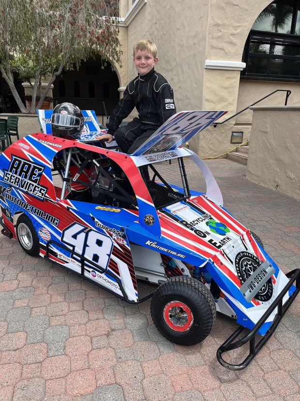 Eight-year-old Ryder Edwards of Ramona poses in his Mini Dwarf race car at the San Diego County Fair's media preview on Wednesday, May 27, at the Del Mar Fairgrounds. He'll compete in a racing competition at the fair on Fourth of July weekend. (Pam Kragen / The San Diego Union-Tribune)