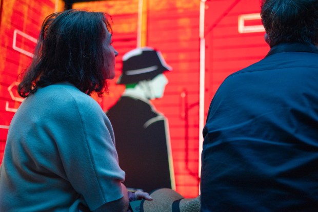 Attendees watch "Holocaust 101," an interactive video shown inside the Spark Interactive bus during its launch event at Crownair Aviation in San Diego on May 3, 2026. (McKenzie Patterson / For The San Diego Union-Tribune)