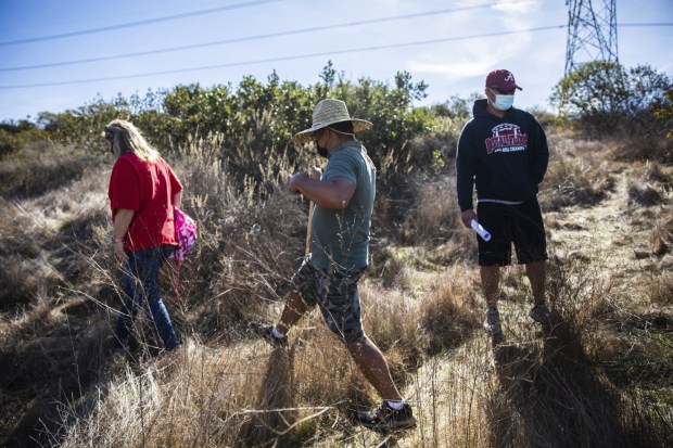 Melissa Graves, Abraham Sarmiento and Reagan Pablo walk a trail on Mother Miguel Mountain Jan. 13, 2021, in search of Maya "May" Millete, who went missing last Thursday evening. (Kristian Carreon / U-T file)