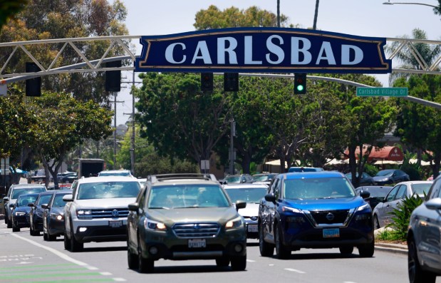 Cars under the Carlsbad sign in summer 224. (K.C. Alfred / The San Diego Union-Tribune)